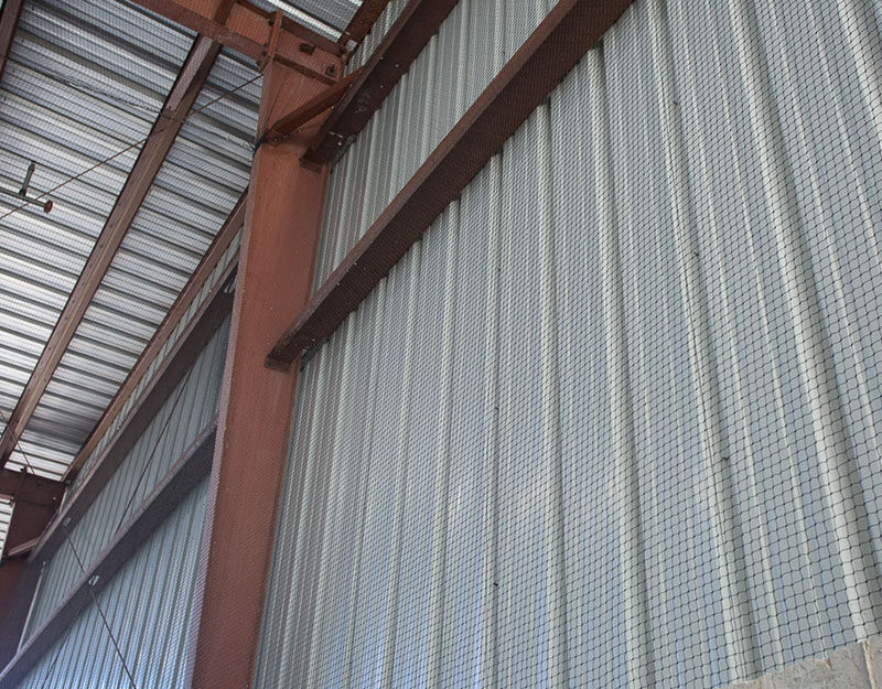 The side and corners of a warehouse after a Cat-Guard Exclusion System is installed to keep out birds and wildlife